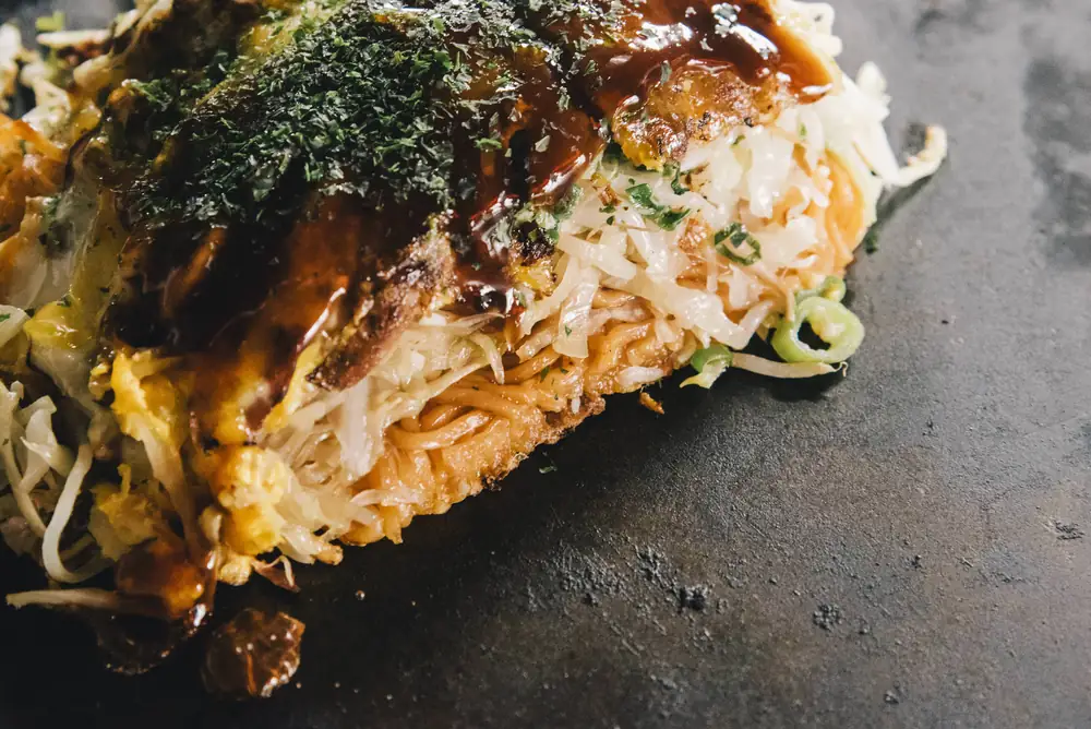 鉄板の上の、辛麺入りのお好み焼き