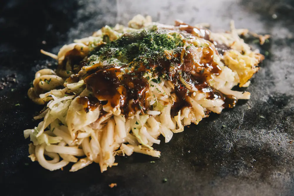 鉄板の上の、うどん入りのお好み焼き